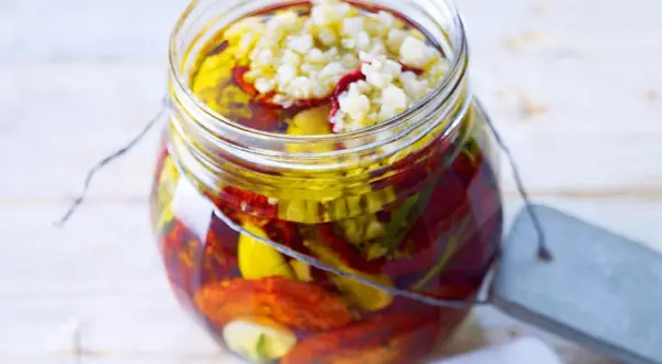 Glas mit getrockneten Tomaten, Knoblauch und Kräutern in Öl. Perfekt zum getrocknete tomaten einlegen.