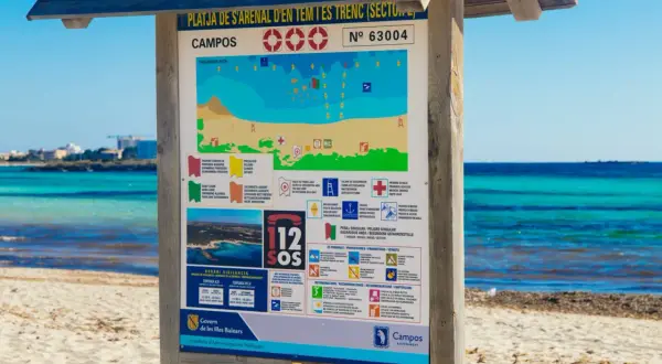 Tablica informacyjna na plaży Campos, Majorka. Znajdziesz tu mapę, zasady bezpieczeństwa i co zabrać na majorkę, by cieszyć się słońcem i morzem.
