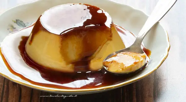 Delizioso creme caramel su un piatto bianco, con una cucchiaiata pronta da gustare.