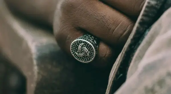Męska dłoń z sygnetem w kształcie potrójnego rogu Odyna. Co to za symbol?