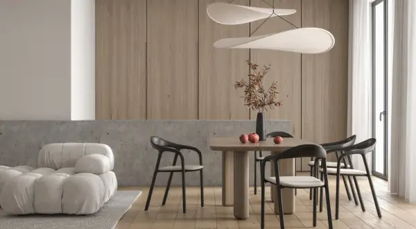 Jadalnia w stylu minimalistycznym: drewniane panele, betonowy blat, jasna sofa, drewniany stół z krzesłami i ozdobna lampa.