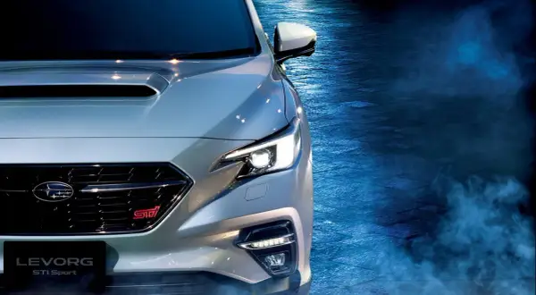 Srebrny Subaru Levorg STI Sport z włączonymi światłami, otoczony niebieską mgłą, gotowy do jazdy.