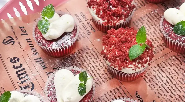Red velvet muffins med fluffig frosting och myntablad. En härlig syn av röda sammetsmuffins!