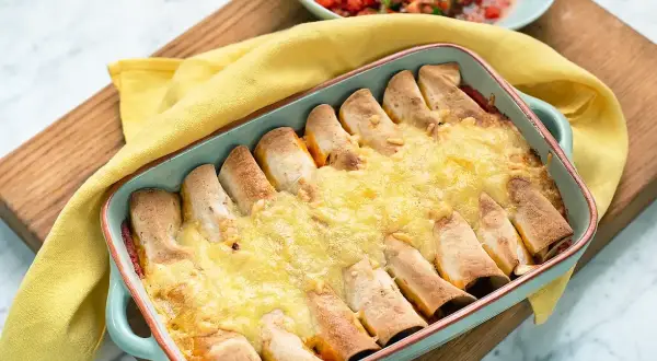 Enchiladas kyckling i ugnsform, gyllene och gratinerade med ost. Serveras med en fräsch tomatsalsa.