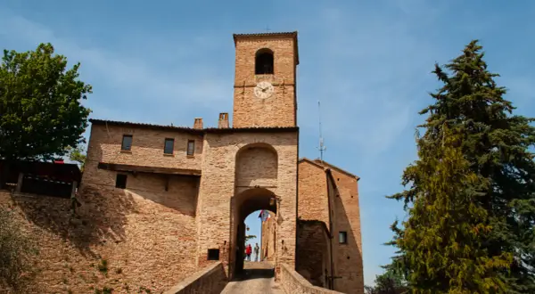 Porta Urbica a Montefeltro: un arco in mattoni con torre dell'orologio, ideale per scoprire cosa vedere in questo borgo storico.