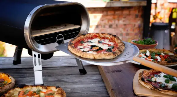En pizzasten ugn med perfekt temperatur för krispiga pizzor. Flera läckra pizzor ligger redo att serveras.