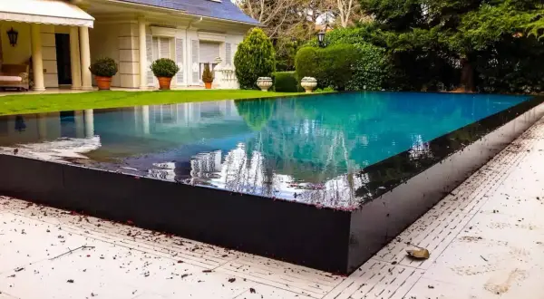 Impresionante piscina de borde infinito, un oasis de **piscinas de lujo modernas** junto a una villa blanca.