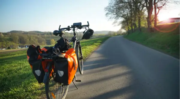 Rower z sakwami na drodze, idealny na długą podróż. Jak nie zasnąć w trasie? Wystarczy piękny widok i cel!