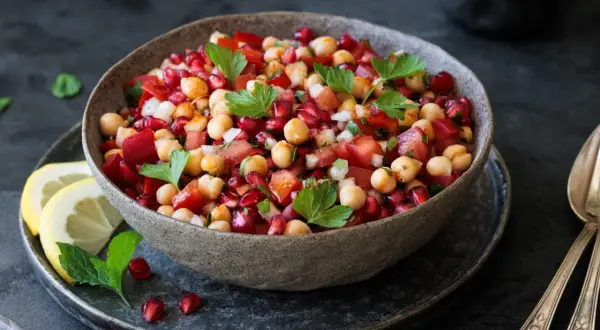 Bunter Kichererbsensalat mit Granatapfelkernen, Tomaten und Petersilie. Perfekt als Beilage oder leichtes Hauptgericht. Was passt zu Kichererbsensalat? Frisches Brot!