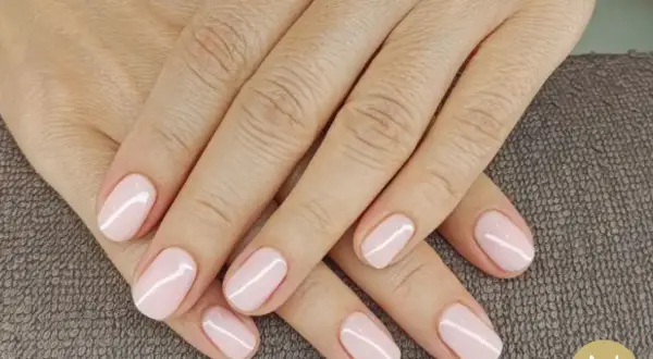 Mani curate con unghie corte e smalto rosa pastello. La forma unghie corte è elegante e pratica, perfetta per ogni occasione.