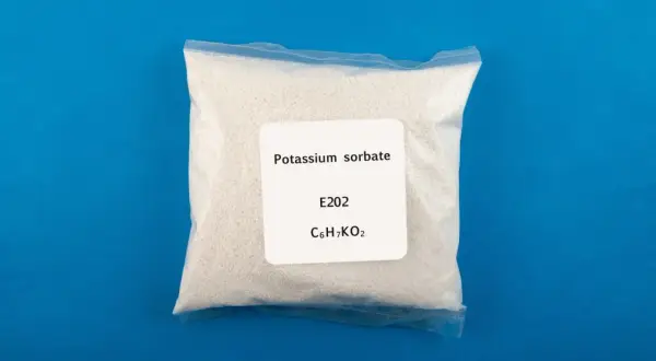 Biały proszek w przezroczystej torebce, oznaczony jako sorbinian potasu (potassium sorbate), E202, C6H7KO2.