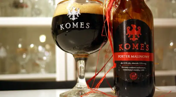 Komes Porter Malinowy w kielichu i butelce, ozdobionej czerwonymi wstążkami. Piwo z nutą malin, wanilii i chili.