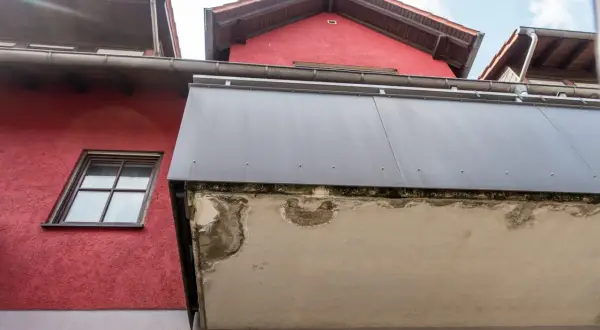 Betonplatte eines Balkons zeigt deutliche Schäden, die auf eine notwendige Sanierung hindeuten.