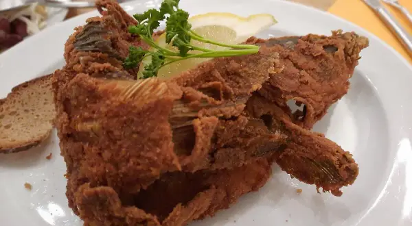 Knusprig panierter Karpfen, garniert mit Zitrone und Petersilie, serviert mit Brot. Ein Fest für Genießer – der beste Karpfen Frankens!