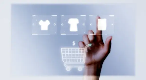 Mano tocando pantalla virtual con iconos de camisetas y carrito de compra. Guía para saber como abrir una tienda online en España.