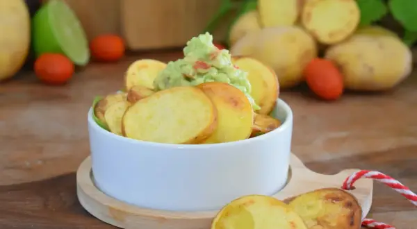 Selbstgemachte Kartoffelchips mit Guacamole, ein leckerer Snack.