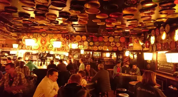 Interno di un locale a Bruxelles, con il soffitto e le pareti ricoperti di tappi e dischi di latta. Un'atmosfera da vero delirium.