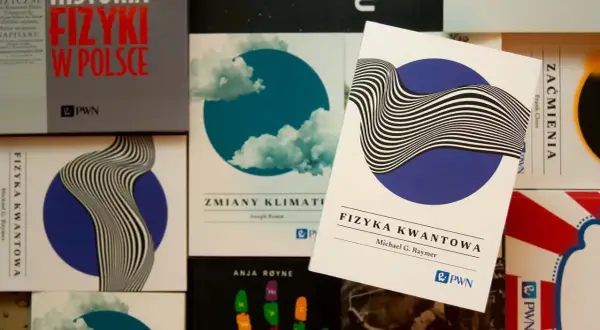 Książki o fizyce kwantowej i historii fizyki w Polsce. Jedna z nich, "Fizyka kwantowa" Michaela G. Raymera, leży na wierzchu.