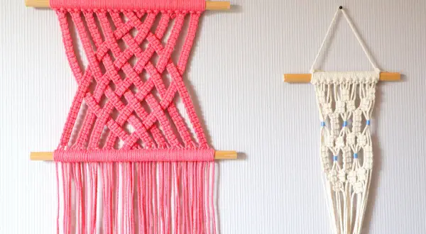Deux tentures murales en macramé : une rose vif avec un motif croisé, et une écru avec des perles bleues. Idéal pour un tuto macramé mural.