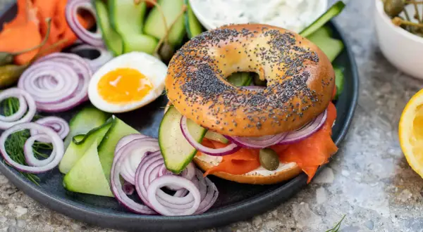 En bagel med lax, färskost, rödlök, gurka och kapris. Ett perfekt brunch recept för en lyxig start på dagen.