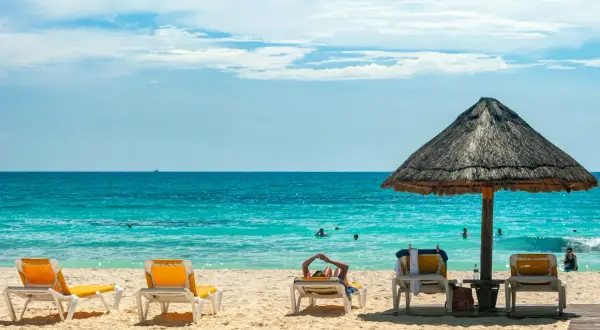 Słońce, plaża i turkusowe morze – idealne miejsce na wakacje **ultra all inclusive**. Leżaki czekają na gości.