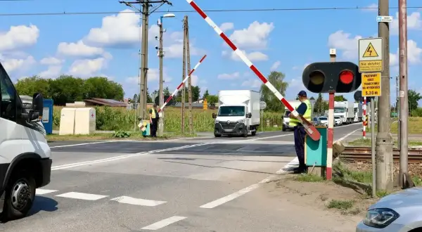 Pracownicy obsługują rogatki na przejeździe kolejowym. Zastanawiasz się, po jakim czasie przychodzi mandat z przejazdu kolejowego?