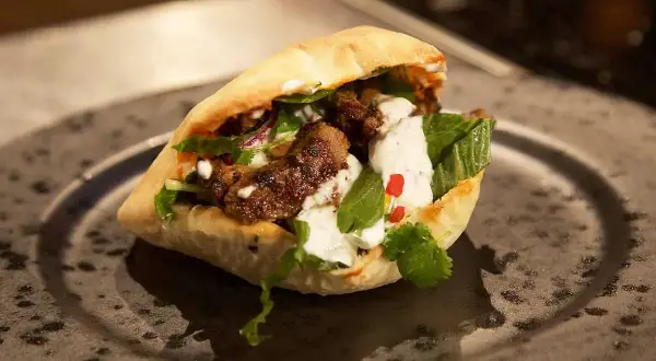 En saftig kebabrulle med kött, grönsaker och vit sås. Perfekt för dig som söker ett gott kebabkrydda recept.