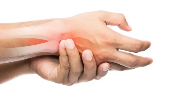 Mano che si tiene il polso con aree rosse che indicano dolore. Possibili cause di dolori alle caviglie e polsi.