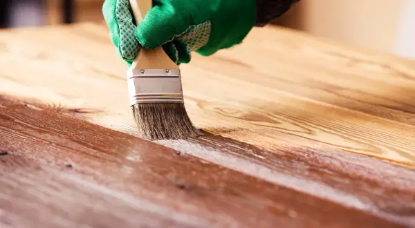 Application d'un vernis sur du bois. Le temps de séchage du vernis bois est crucial pour un résultat parfait.