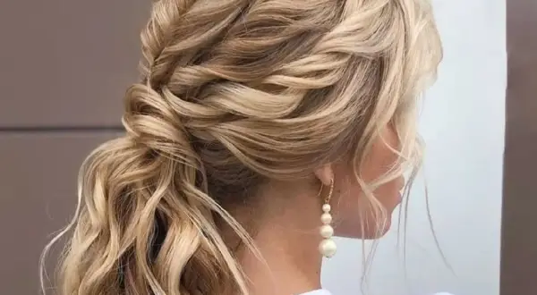 Peinado de novia con trenzas y ondas sueltas, ideal para bodas de ensueño.