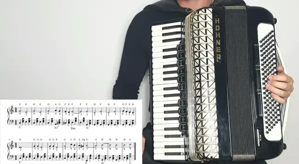Osoba gra na akordeonie HOHNER, a przed nią leży nuta z zapisem melodii. To z pewnością materiał na przeboje na akordeon!