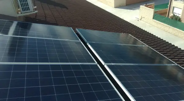 Paneles solares en tejado de tejas marrones. La instalación busca la mejor solución para evitar sombras y maximizar la captación solar.