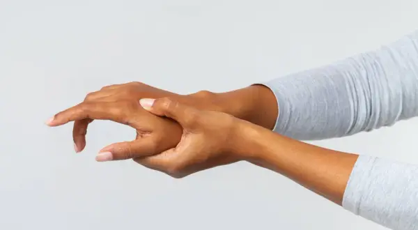 Mano che si massaggia il dorso per alleviare un fastidioso dolore.