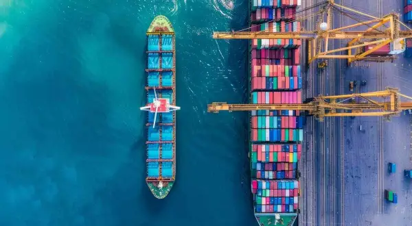 Große Containerschiffe im Hafen, bereit für den **time charter**. Kräne laden und löschen bunte Fracht.