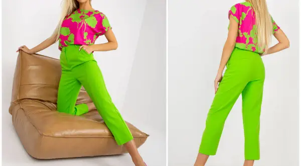 Jaka bluzka do zielonych spodni? Modelka prezentuje stylizację z fuksjową bluzką w zielone liście i neonowe, zielone spodnie.