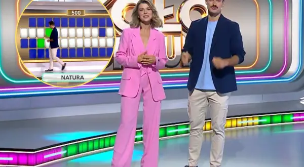 Prowadzący w studiu "Koło fortuny" wyjaśniają, koło fortuny jak wziąć udział. Widoczna plansza z literami i polem 500.
