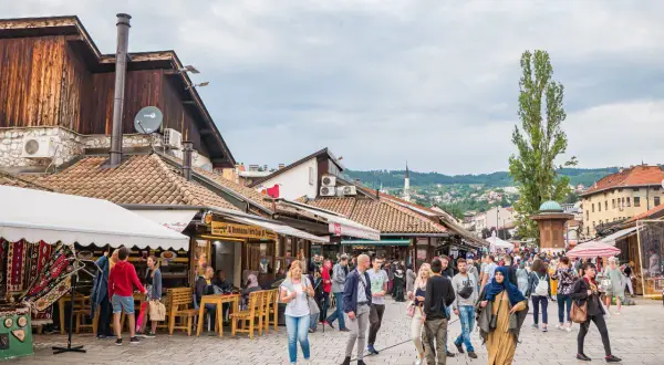 Tętniący życiem bazar w Bośni i Hercegowinie. Ludzie spacerują wśród straganów i kawiarni, odkrywając lokalne atrakcje.