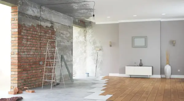Renovación de casas con encanto: ladrillo visto, escalera, rodillo y suelo de madera en proceso.