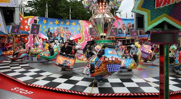 Bunte Fahrgeschäfte drehen sich auf der Kirmes Bergneustadt. Menschen lachen und genießen die Fahrt.