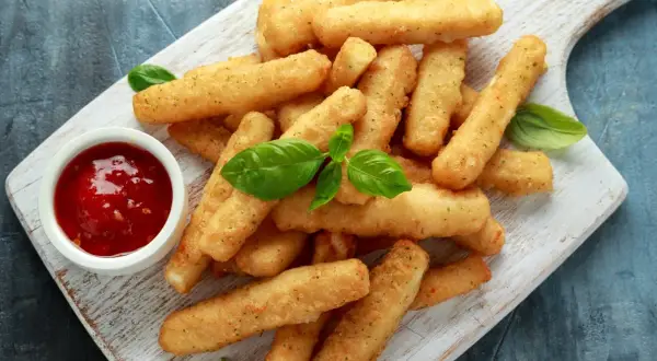 Jak zrobić frytki z halloumi – idealna przekąska na imprezę. Złociste paluszki serowe z sosem pomidorowym i bazylią.