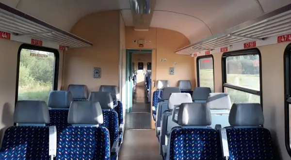 Puste siedzenia w wagonie kolejowym, gotowe na podróż pociągiem w Bieszczady.