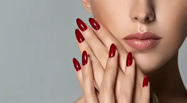Mani eleganti con unghie a mandorla color rosso ciliegia, perfette per una durata semipermanente impeccabile.