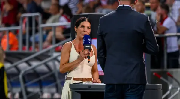 Dziennikarka z mikrofonem Canal+ pyta, kto pokaże ekstraklasę w przyszłym sezonie. Widownia na stadionie czeka na odpowiedź.