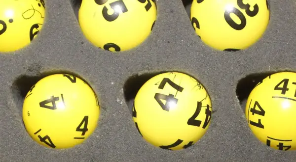 Żółte kulki z numerami do lotto, w tym 4, 41, 47, 30. Czy trójka w lotto plus jest płatna?