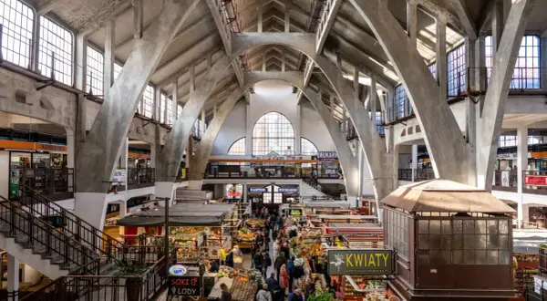 Das Innere der Markthalle, ein Wahrzeichen von Wrocław, mit seinen beeindruckenden Betonbögen und dem lebhaften Treiben der Marktstände.