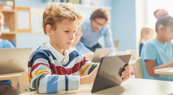 Schüler lernen mit Tablets und Laptops. Digitale Medien in der Schule fördern interaktives Lernen.