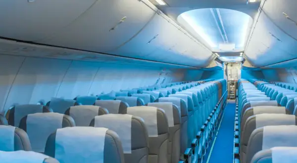 Wnętrze samolotu Boeing 787 LOT. Widok na rzędy pustych siedzeń, które tworzą rozkład miejsc w kabinie pasażerskiej.
