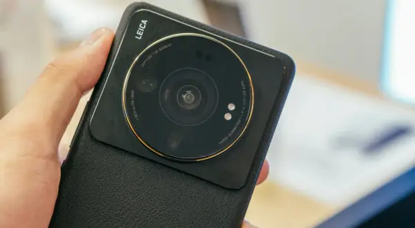 Dłoń trzyma czarny telefon Xiaomi z dużym modułem aparatu Leica.