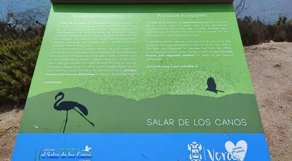 Un cartel informativo sobre el Salar de los Canos, un humedal costero y antiguo salinar, con siluetas de aves.