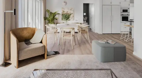 Ett ljust och luftigt vardagsrum med matplats i klassisk nordisk design. En bekväm fåtölj och en grön pall skapar en inbjudande atmosfär.